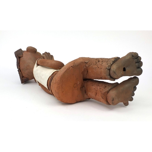 2362 - A comical Chinese terracotta figure seated on a bench, 50cm high