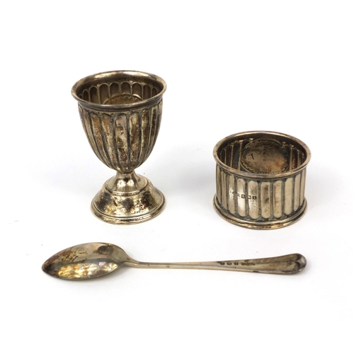 2449 - Silver three piece Christening set comprising an egg cup, spoon and napkin ring with fluted decorati... 