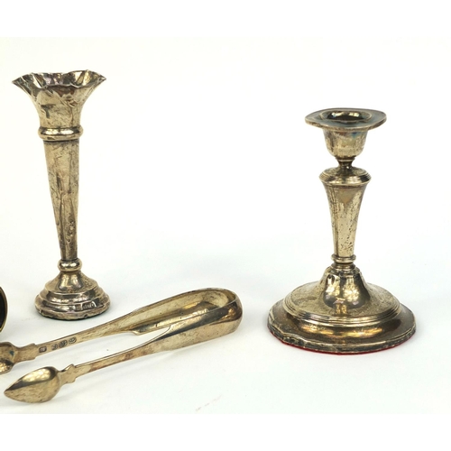 2436 - Silver items comprising a pair of Georgian sugar tongs, candle stick, bud vase and pair of silver mo... 