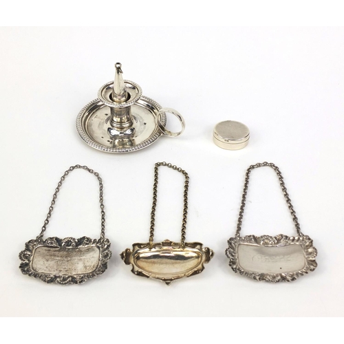 2415 - Silver items comprising a chamber stick, three decanter labels and a pill box, various hallmarks, th... 