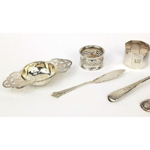 2469 - Silver items comprising three Georgian spoons, Scottish spoon, a strainer, two napkin rings and butt... 