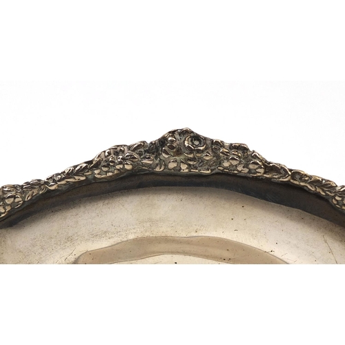 2451 - Circular silver three footed dish with floral boarder, indistinct mark to the base, 17.5cm in diamet... 