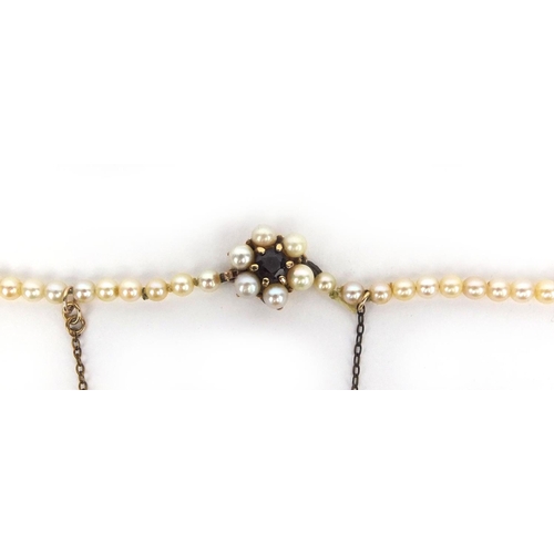 2604 - Single string cultured pearl necklace with 9ct gold clasp set with a garnet, 40cm long, approximate ... 