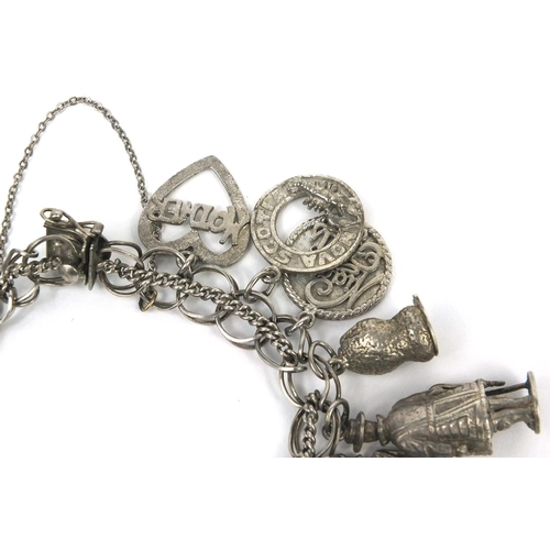 2563 - Silver charm bracelet with a selection of mostly silver charms, approximate weight 66.7g