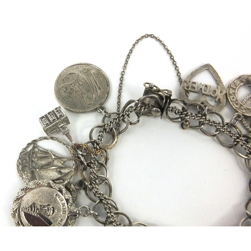 2563 - Silver charm bracelet with a selection of mostly silver charms, approximate weight 66.7g