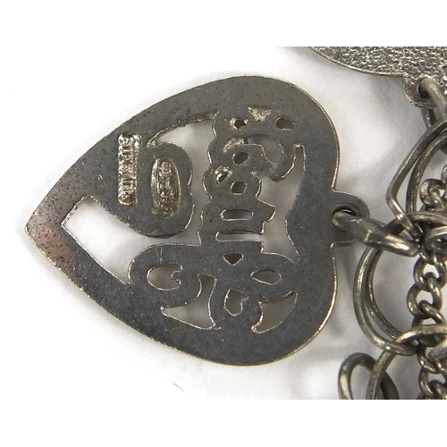 2563 - Silver charm bracelet with a selection of mostly silver charms, approximate weight 66.7g