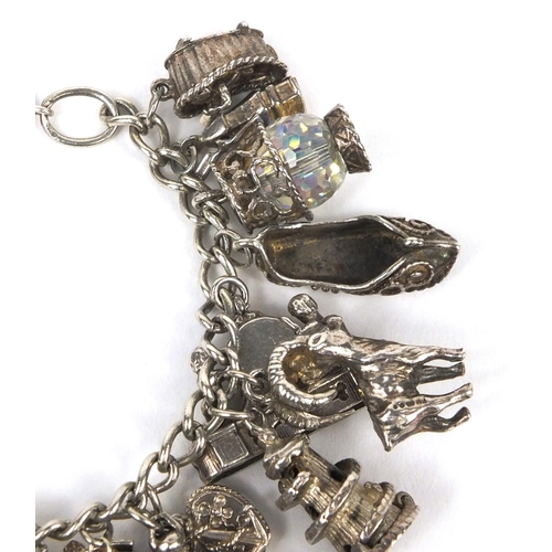 2514 - Heavy silver charm bracelet with selection of mostly silver charms including genie lamp, rocking cha... 