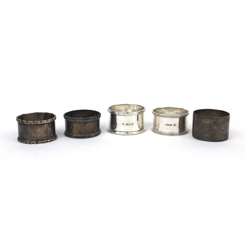 2477 - Five assorted circular silver napkin rings, one with engine turned decoration, various hallmarks, ap... 