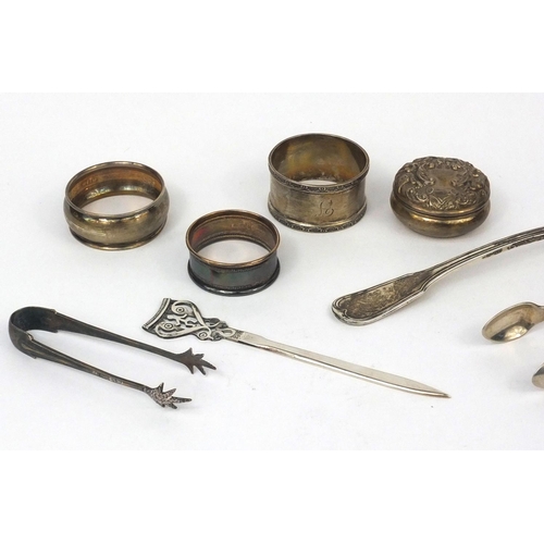 2473 - Silver items comprising Scottish sifting spoon, Victorian sugar tongs, three napkin rings, pair of s... 