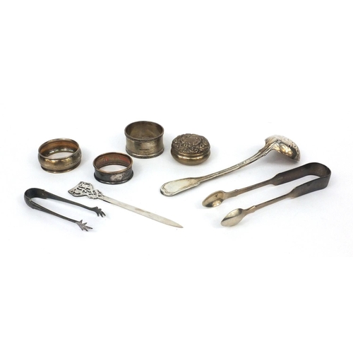 2473 - Silver items comprising Scottish sifting spoon, Victorian sugar tongs, three napkin rings, pair of s... 