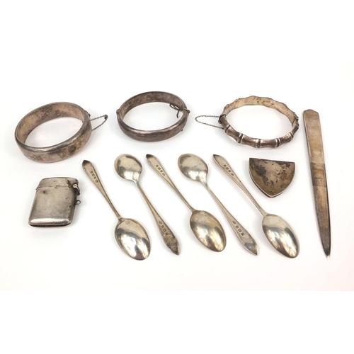 2418 - Silver items including three bangles, vesta, letter opener and teaspoons, approximate weight 187.0g