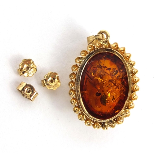 2659 - 9ct gold natural amber pendant and three gold coloured earring backs, 2cm long, approximate weight 1... 