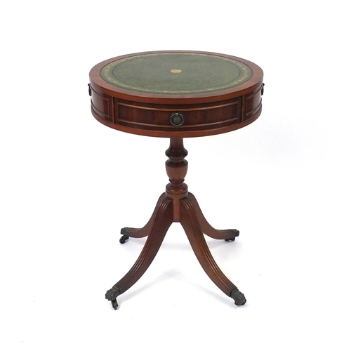 2064 - Circular yew drum table with tooled leather top, fitted with two frieze drawers and brass paw feet, ... 