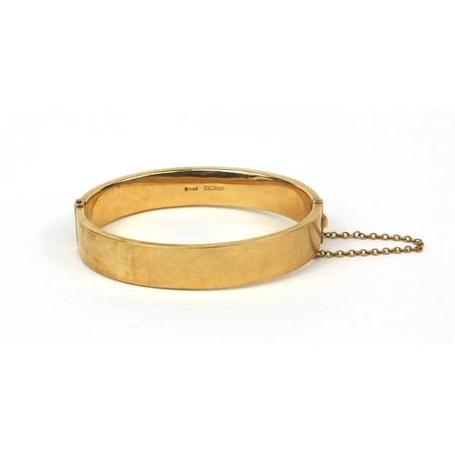 2501 - 9ct gold bangle with floral chased decoration, 6.5cm long x 1.3cm wide, approximate weight 17.8g