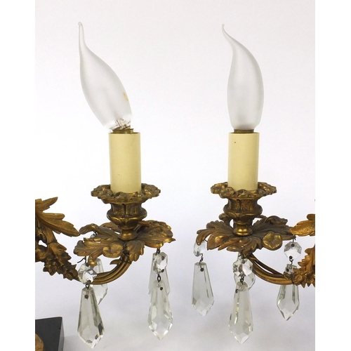 2074 - Pair of 19th century ormolu three branch candelabrum, each with two putti, cut glass drops and raise... 