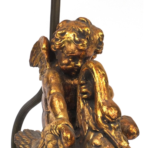 2243 - Ornate gilt lamp modelled as a putti riding a swan, with faux marble base, and silk lined shade, 76c... 