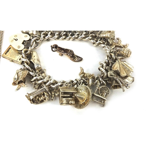 2583 - Heavy silver charm bracelet with a large selection of mostly silver charms including a spinning whee... 