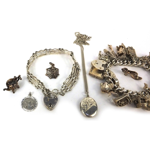 2583 - Heavy silver charm bracelet with a large selection of mostly silver charms including a spinning whee... 