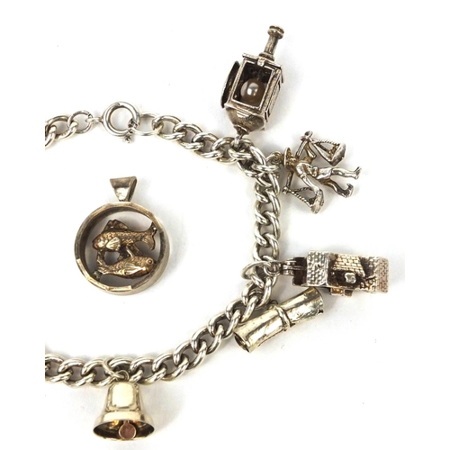 2621 - Silver charm bracelet with selection of mostly silver charms including railway lantern, Dutch figure... 