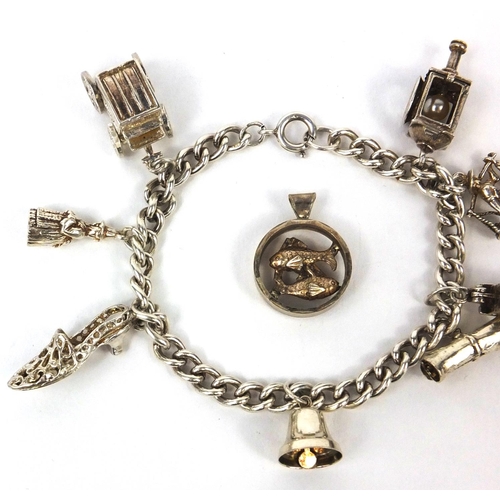 2621 - Silver charm bracelet with selection of mostly silver charms including railway lantern, Dutch figure... 