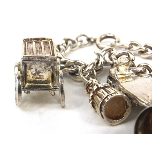 2621 - Silver charm bracelet with selection of mostly silver charms including railway lantern, Dutch figure... 