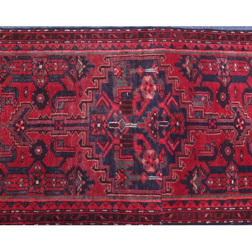 2093 - Rectangular Hamadan carpet runner with an all over geometric and floral design onto a red ground, 25... 