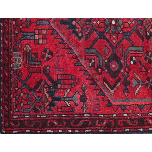 2093 - Rectangular Hamadan carpet runner with an all over geometric and floral design onto a red ground, 25... 