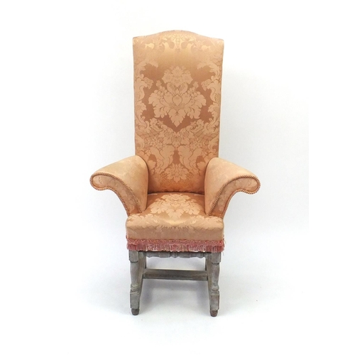 2058 - Bleached wooden framed child's correction chair with outswept arms and peach upholstery, 110cm high