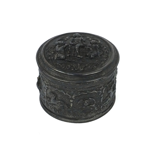 601 - Indian unmarked cylindrical silver box and cover, profusely embossed with animals and figures amongs... 