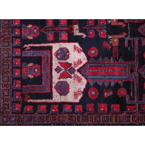 2055 - Rectangular Baluchi rug decorated with animal and floral motifs onto a red and dark blue ground, 230... 