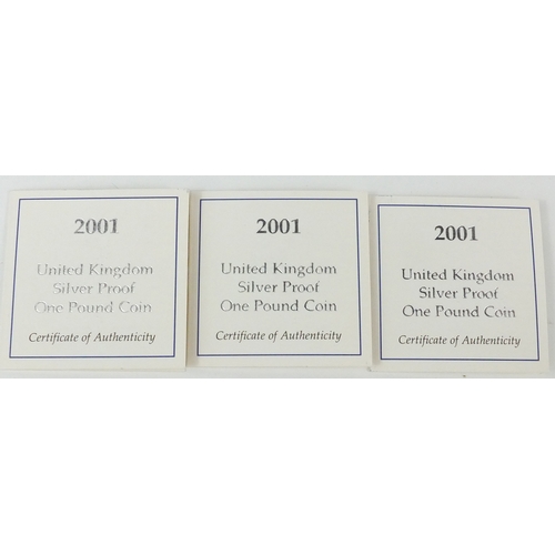 2734 - Three 2001 United Kingdom silver proof £1 coins, each with fitted cases and certificates