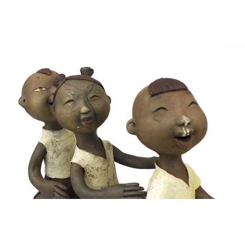 2360 - Comical Chinese terracotta figure group of three children seated on a branch, 37cm high