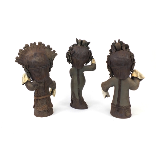 2257 - Three Chinese terracotta figures each of robed girls striking poses, the largest 38cm high