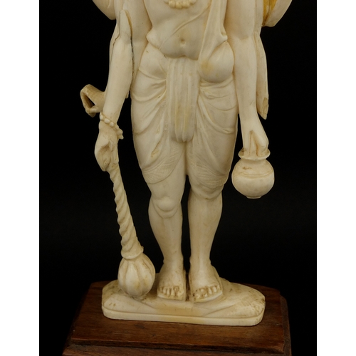 614 - Two Indian carved ivory figures, each raised on hard wood bases, the largest overall 20cm hig