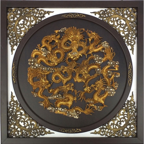 37 - Circular relief panel of golden dragons with pierced spandrels, in a square frame, 88cm square
