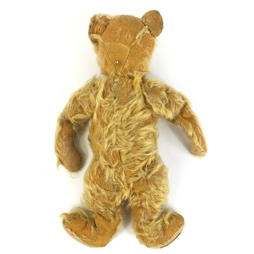 411 - Antique golden teddy bear with jointed limbs and Farnell's Alpha Toys label, 28cm high