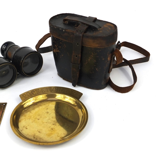 657 - Group of objects including a nude boy ashtray, 19th century brass poachers plaque, pair of binocular... 