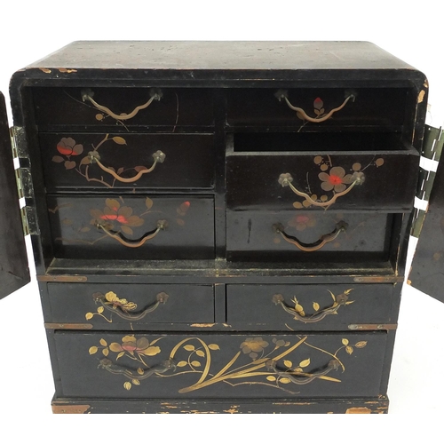 244 - Japanese table cabinet hand painted with birds of paradise, fitted with a pair of doors and nine dra... 