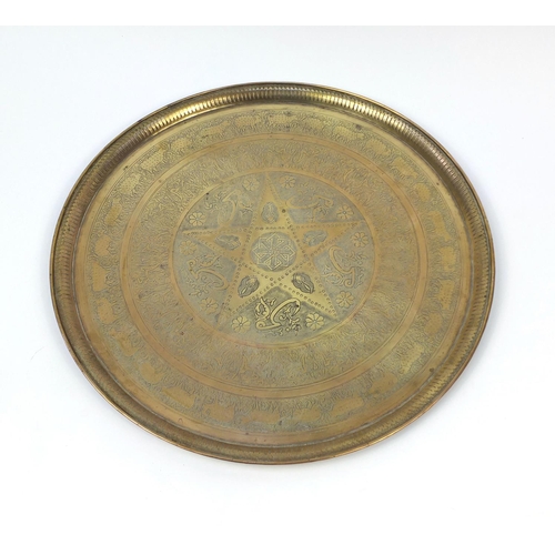 654 - Large Middle Eastern brass tray, engraved with script and floral motifs, 58cm in diameter