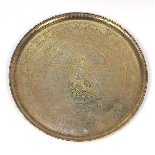 654 - Large Middle Eastern brass tray, engraved with script and floral motifs, 58cm in diameter