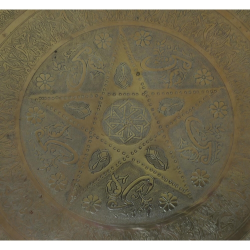 654 - Large Middle Eastern brass tray, engraved with script and floral motifs, 58cm in diameter