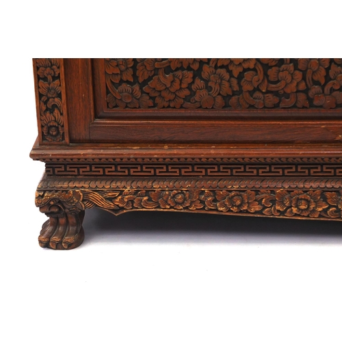 2019 - Indonesian hardwood side cabinet carved with flowers and foliage fitted with four doors and a drawer... 