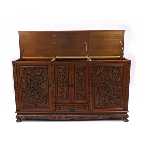 2019 - Indonesian hardwood side cabinet carved with flowers and foliage fitted with four doors and a drawer... 