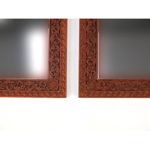 2020 - Pair of ornate Thai hardwood mirrors, each carved with foliage, each 66cm x 51cm