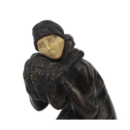 2093 - Bronze study of an Art Deco female wearing hand warmers, raised on a circular marble base, overall 3... 