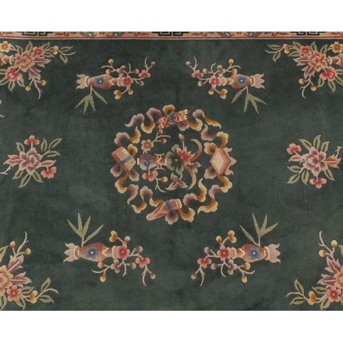 85 - Chinese super wash carpet with predominantly green ground and flowers in vases, approximately 340cm ... 