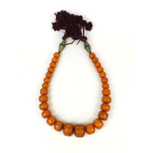 620 - Very large ethnic amber colour bead necklace, overall 110cm in length, the largest bead 5cm in diame... 