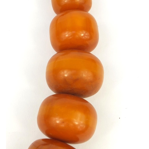 620 - Very large ethnic amber colour bead necklace, overall 110cm in length, the largest bead 5cm in diame... 