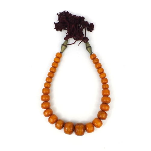 620 - Very large ethnic amber colour bead necklace, overall 110cm in length, the largest bead 5cm in diame... 