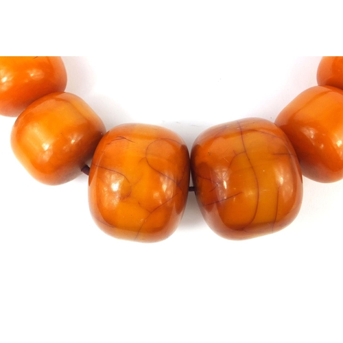 620 - Very large ethnic amber colour bead necklace, overall 110cm in length, the largest bead 5cm in diame... 